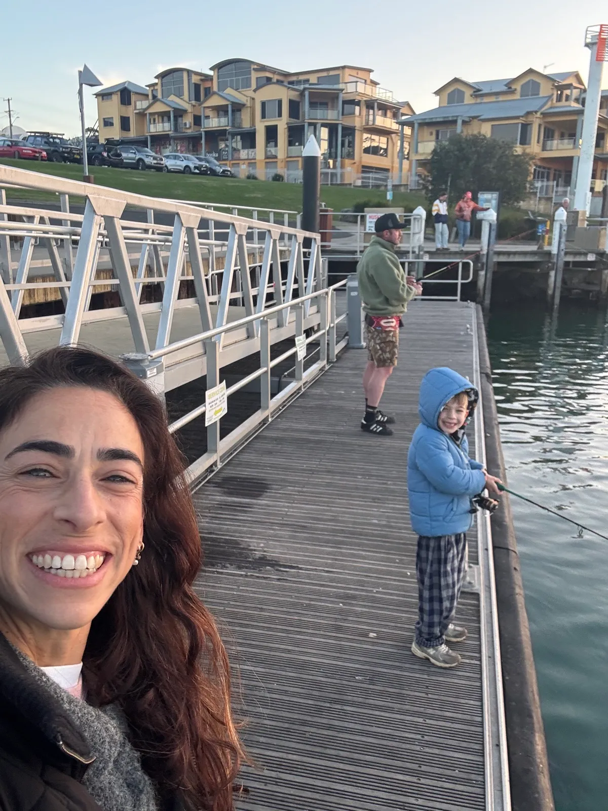 A family fishing off the wharf together on a winter afternoon
