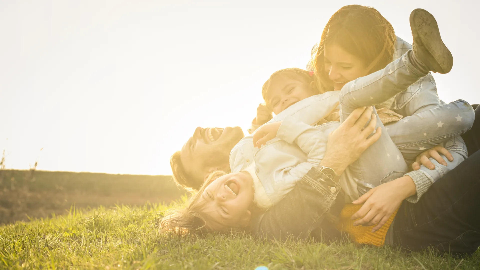 A family walking together through a sunlit park at golden hour